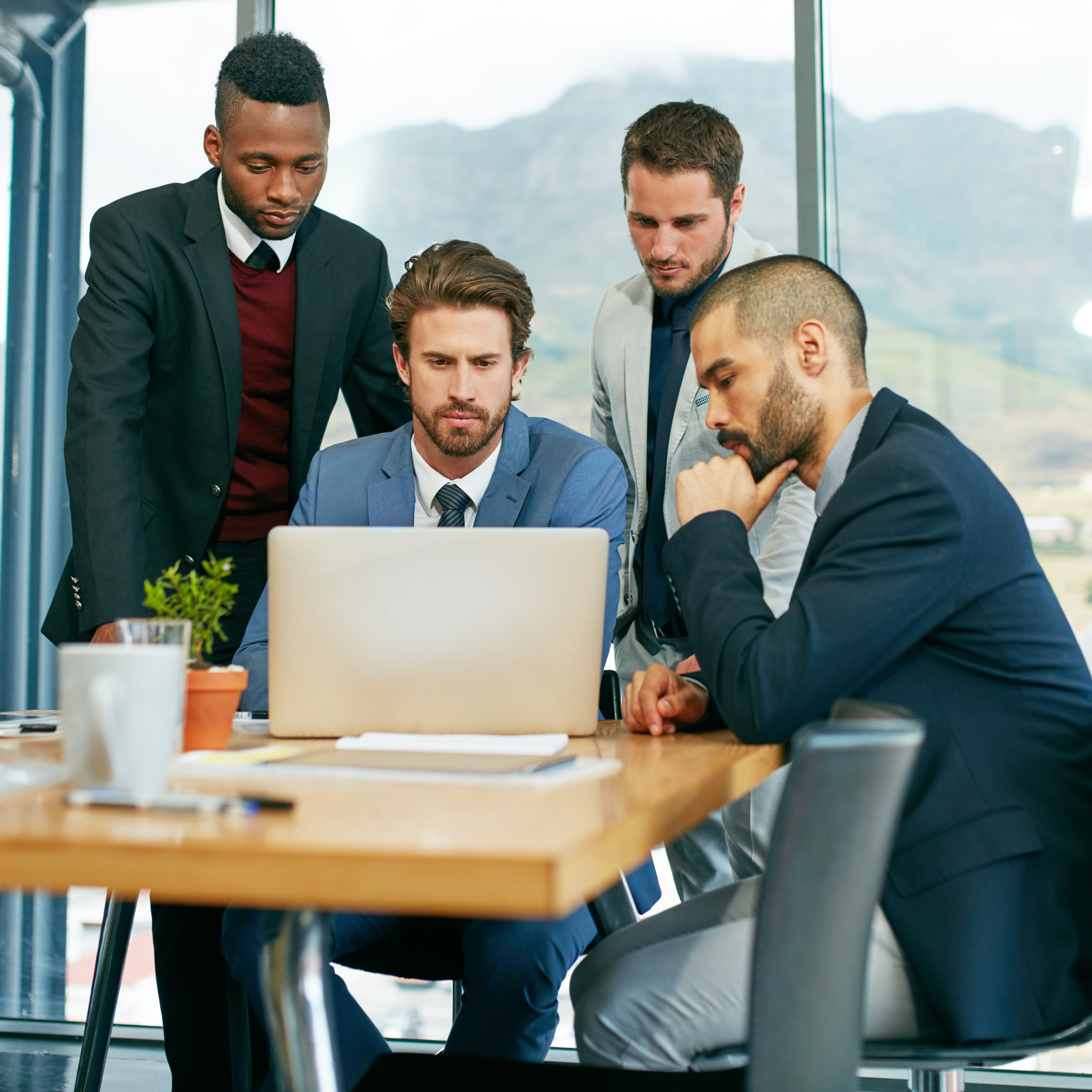 Collaboration, laptop and meeting with business people in office for brainstorming, planning or strategy. Computer, project management and research with employee group of men in workplace together.